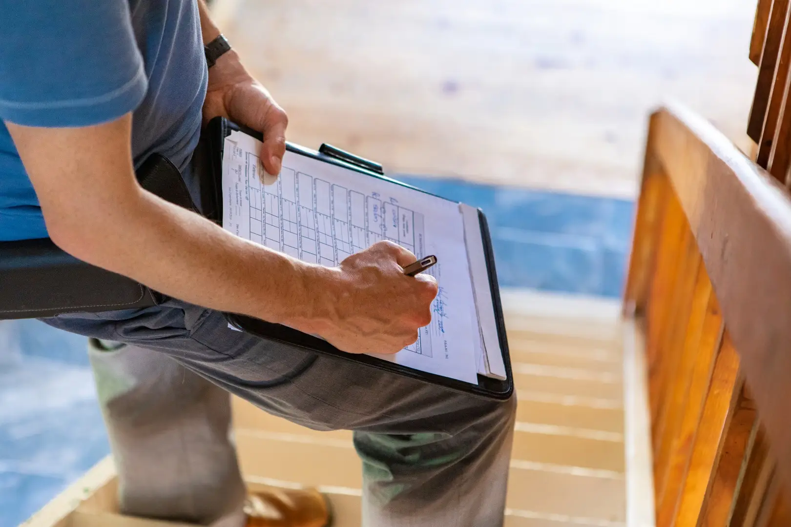 A man takes notes on his home inspections work sheet, detailing what he has found during his inspection